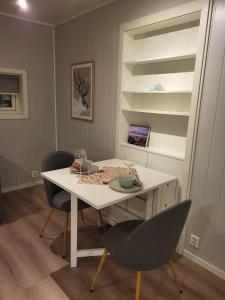 特羅姆瑟的住宿－Elvenes, krypinn for to，一间配备有白色桌子和两把椅子的用餐室