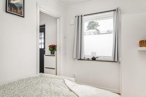 a bedroom with white walls and a mirror at Modern New Stylish Apartment in Åkersberga