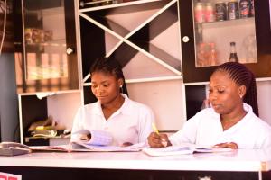 two women in white shirts sitting at a table at Royal Suites and Apartments in Jidu