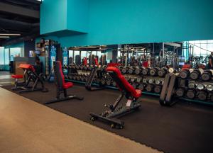a gym with several rows of dumbbells and red chairs at Luxe Azure Apartment in Baku