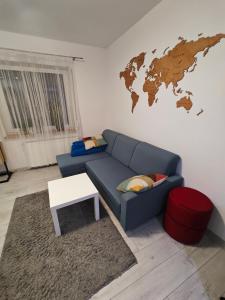 a living room with a blue couch and a map on the wall at Mieszkanie Tarnowo Podgórne in Tarnowo Podgórne