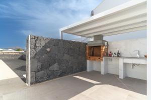 a kitchen with a stone wall and a counter at Vv Villa Secretos de Yaiza 1 by Hh - private pool & BBQ in Yaiza