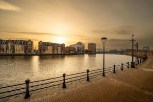 a body of water with buildings and a street light at River Side Apartment, City Centre - Beautiful View and Free Parking! in Belfast