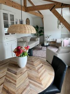 una sala de estar con una mesa con un jarrón de flores en Veldhorst Apartments en Leiden