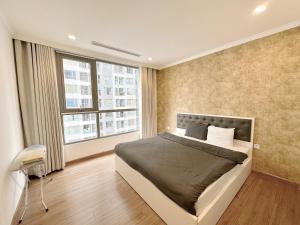 een slaapkamer met een bed en een groot raam bij City Center 4BR Apartment in Hanoi