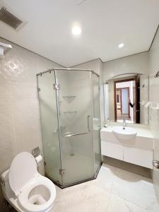 een badkamer met een douche, een toilet en een wastafel bij City Center 4BR Apartment in Hanoi