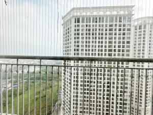 een balkon met uitzicht op een hoog gebouw bij City Center 4BR Apartment in Hanoi