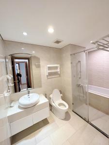 een badkamer met een toilet, een wastafel en een douche bij City Center 4BR Apartment in Hanoi