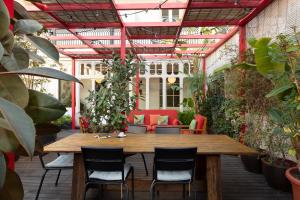 een patio met een houten tafel, stoelen en planten bij Praktik Garden in Barcelona