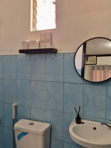a bathroom with a mirror and a toilet and a sink at Casa Olivia in Coron