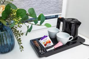 a tray with a coffee maker and cups on a counter at Ventspils jahtu osta, Ventspils Marina in Ventspils