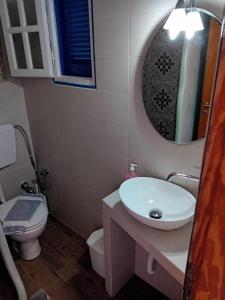 a bathroom with a sink and a toilet and a mirror at SOHOROS STUDIOS in Iraklia