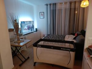 Zimmer mit einem Bett, einem Tisch und einem TV in der Unterkunft DISNEY - PARIS 5 Min DE DISNEY - PK privé gratuit - 4 personnes - Terrasse jardin in Chessy