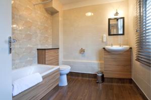 uma casa de banho com uma banheira, um WC e um lavatório. em The Shrewsbury Hotel Wetherspoon em Shrewsbury