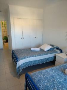 um quarto com 2 camas e um armário branco em House with amazing beach view! em Carvoeiro