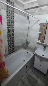 a bathroom with a bath tub and a sink at Однокомнатная квартира, Новая! in Mayevka