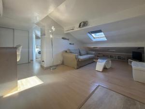 a living room with a couch and a television at Zone piétonne - Wifi, AC, 2 pers in Nice