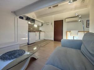 a living room with a blue couch and a kitchen at Zone piétonne - Wifi, AC, 2 pers in Nice