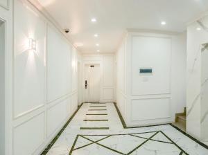 um corredor com paredes brancas, uma porta e um piso de azulejo em ROSA QUEEN HOTEL em Bien Hoa