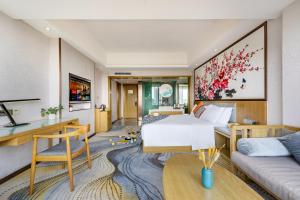 a bedroom with a bed and a living room at 柏高酒店顺德北滘文化公园店 Paco Hotel Shunde Beijiao Midea Group Headquarters store in Shunde