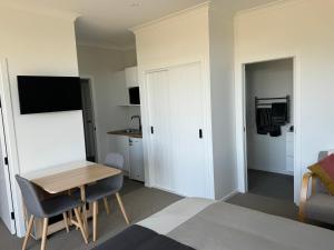 a bedroom with a bed and a desk and a table at Cashmere B&B in Masterton