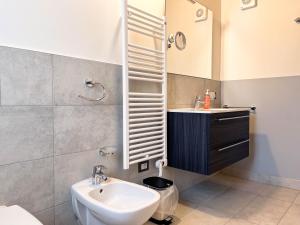 ein Badezimmer mit einem Waschbecken, einem WC und einem Spiegel in der Unterkunft RIAREL- Foresteria Lombarda in Rodero