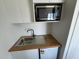 a kitchen with a sink and a microwave at Cashmere B&B in Masterton
