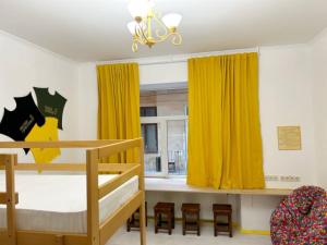 1 dormitorio con 2 literas y cortinas amarillas en BANDERA Hostel, en Leópolis
