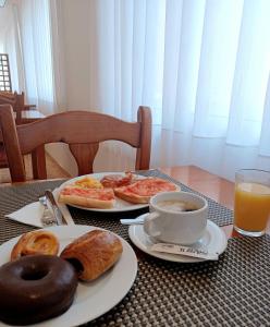 una mesa con platos de desayuno y una taza de café en Hotel Montsia, en Amposta