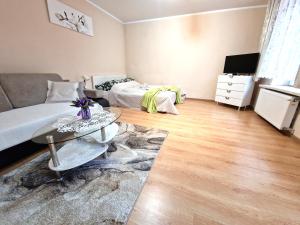 Sala de estar con cama y mesa en ApartHouse Apartamenty Centrum, en Sosnowiec