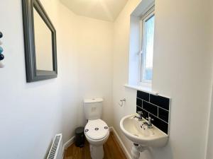een witte badkamer met een toilet en een wastafel bij No.32 by Blue Skies Stays in Bowburn