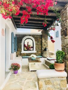 a patio with red flowers hanging from a ceiling at Beautiful Traditional Apt in Ano Mera Mikonos in Ano Mera
