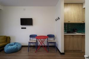ein Wohnzimmer mit einem roten Tisch und 2 Stühlen in der Unterkunft Marshall Gudauri Stylish Apartment By Wehost in Gudauri