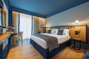 ソレントにあるAra Marisの大きなベッドとデスクが備わるホテルルームです。