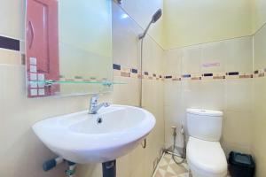 y baño con lavabo y aseo. en RedDoorz Syariah at D'Rizs Homestay en Bukittinggi