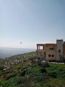 a building on the side of a hill at Bait Al-Bustan Umm Qais in Um Qeis