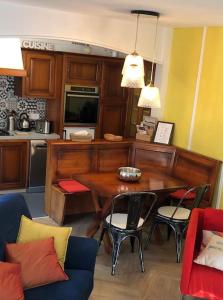 a kitchen with a table with chairs and a microwave at T3 Cosy - Parking privé in Saint-Amarin