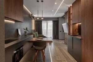 a kitchen with a table and a living room at Boudoir Apartment City Tower - 15th floor in Cluj-Napoca