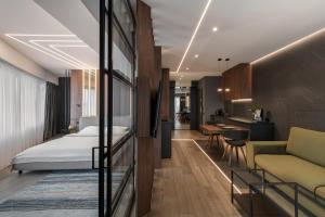 a hotel room with a bed and a kitchen at Boudoir Apartment City Tower - 15th floor in Cluj-Napoca