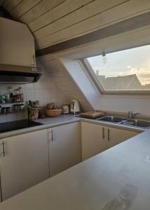 eine Küche mit einem Waschbecken und einem Fenster in der Unterkunft Sunny Penthouse with terras in Gent