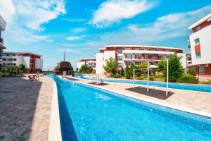 a swimming pool in front of some buildings at Privilege Fort Beach Apartments in Sveti Vlas