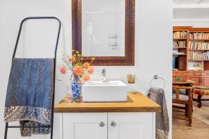 a bathroom with a sink and a mirror at Maison Dandelion in Franschhoek