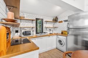 a kitchen with a refrigerator and a washer and dryer at Maison Dandelion in Franschhoek