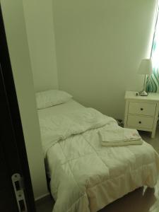 a unmade bed in a small room with a night stand at الخوض السادسة واحة المعرفة in Al Khawḑ