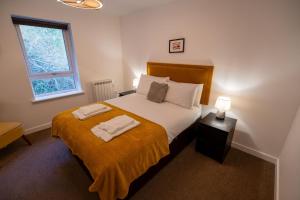 a bedroom with a bed with two towels on it at Dalwhinnie Apartment in Oban