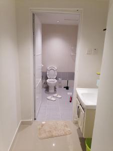 a white bathroom with a toilet and a sink at الخوض السادسة واحة المعرفة in Al Khawḑ
