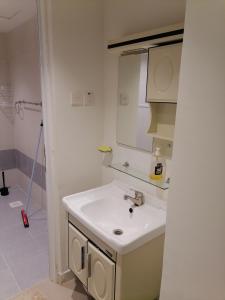 a white bathroom with a sink and a shower at الخوض السادسة واحة المعرفة in Al Khawḑ