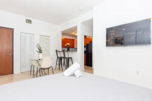 uma sala de estar e cozinha com uma televisão na parede em 1 BDRM Apartment - heart of Downtown - 5 min to Wynwood em Miami