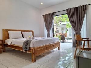 a bedroom with a bed and a large window at Balian Paradise Resort in Selemadeg