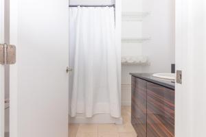 uma casa de banho com uma cortina de chuveiro branca e um lavatório. em 1 BDRM Apartment - heart of Downtown - 5 min to Wynwood em Miami